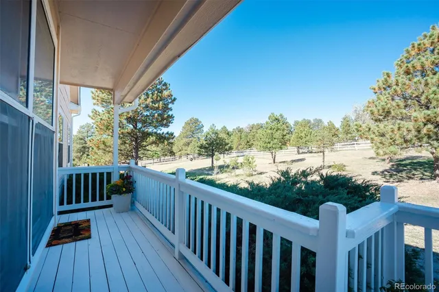 a view of balcony with wooden floor and fence