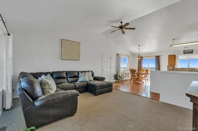 a living room with furniture and a ceiling fan