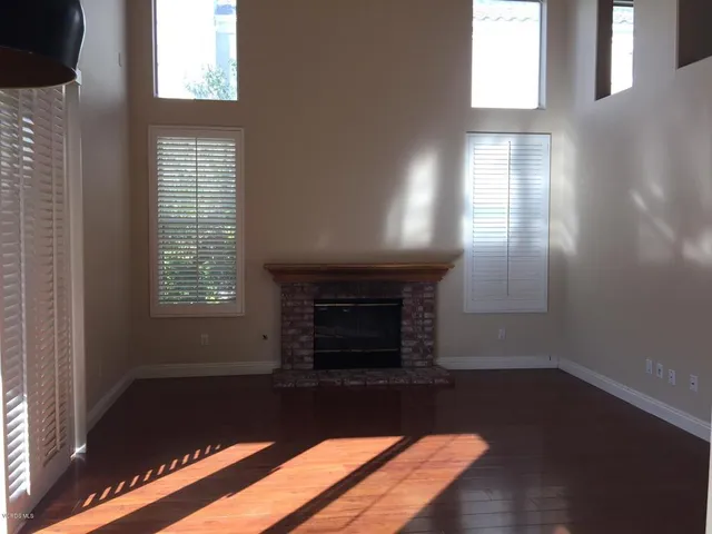 a living room with a fireplace and windows
