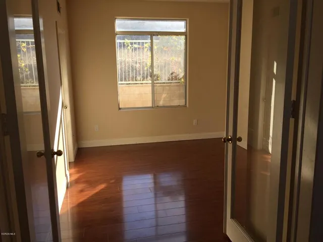 a view of a small space with wooden floor and a window