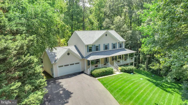 an aerial view of a house with a big yard plants and large trees