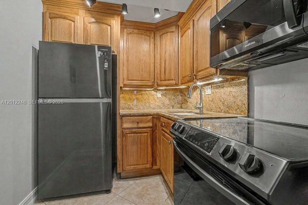 a kitchen with a refrigerator and a sink
