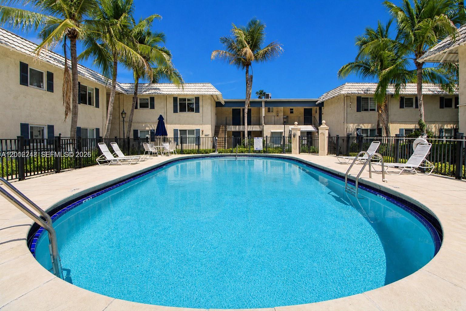 8609 Southwest 68th Court, Unit 22 Pinecrest, FL 33156 - Photo 13 of 15 a view of a house with pool and chairs