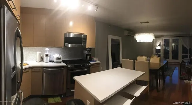 a kitchen with stainless steel appliances a stove a sink refrigerator and a refrigerator