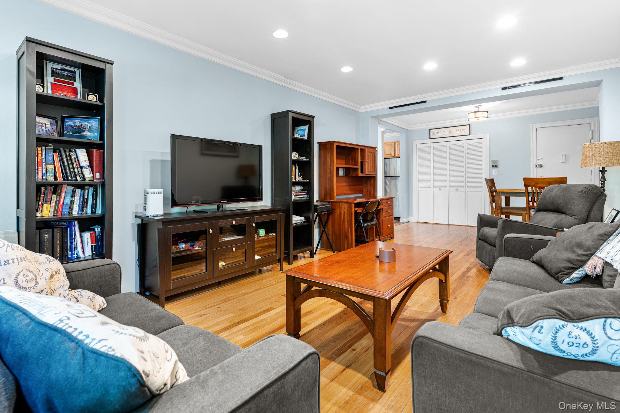 755 Bronx River Road, Unit 4B Bronxville, NY 10708 - Photo 7 of 27 Open-concept living space featuring wood-finish flooring, recessed lighting, crown molding, and multiple windows