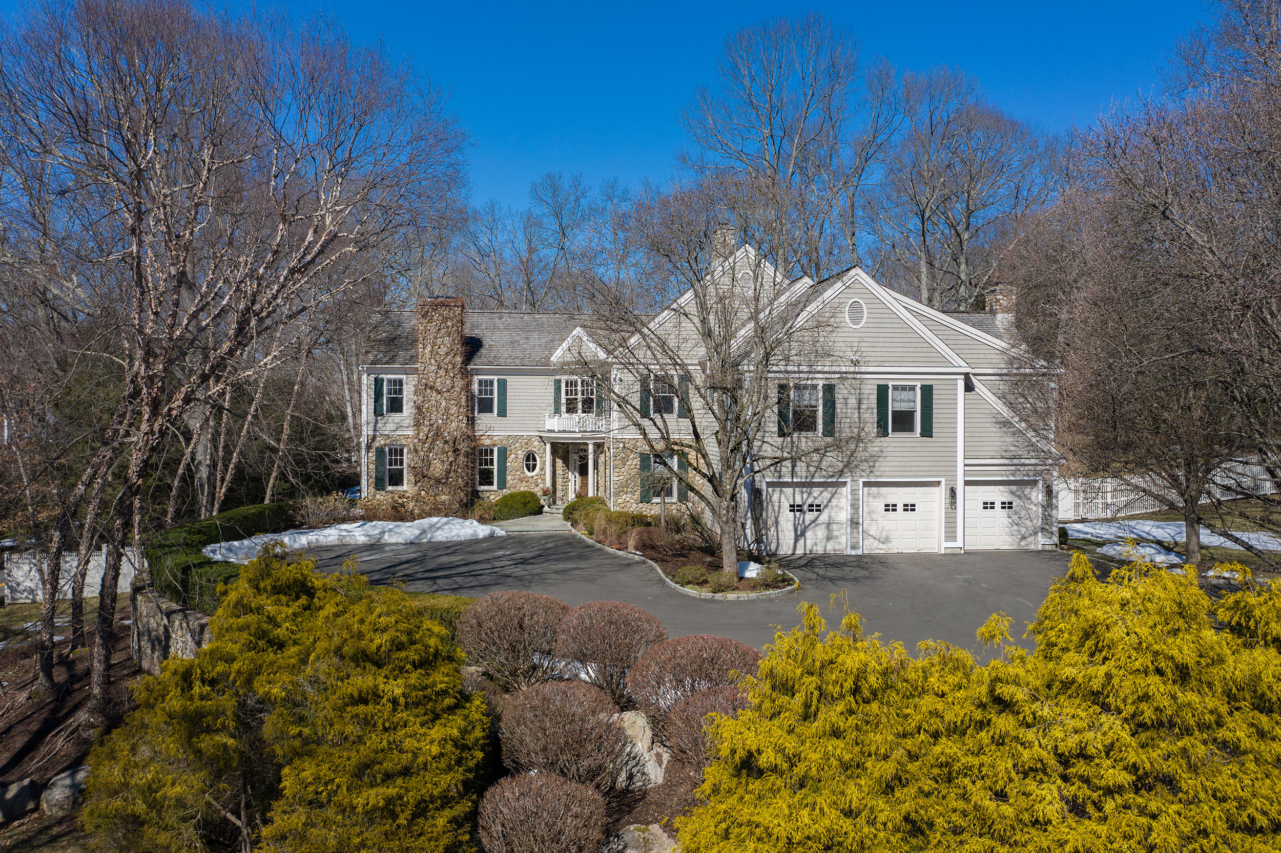 a view of a large white house with a yard covered with snow in front of house