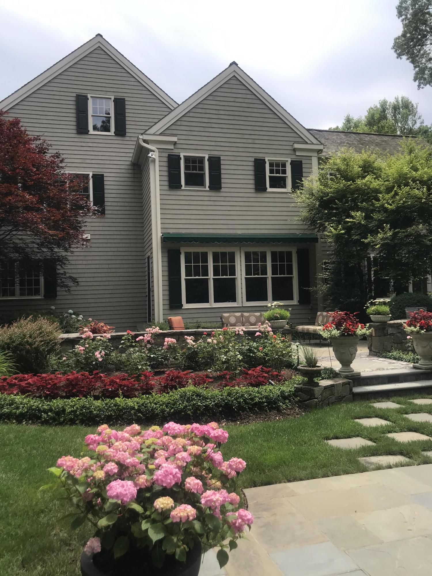 1629 Ponus Ridge Road New Canaan, CT 06840 - Photo 47 of 51 a front view of a house with a yard and many windows