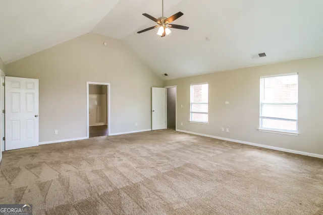 a view of a big room with windows and chandelier fan