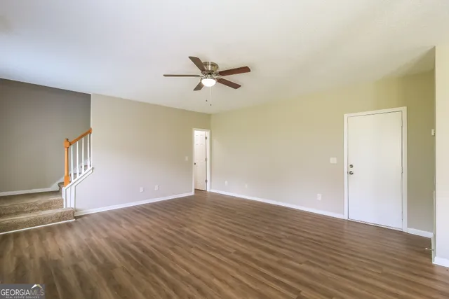 a view of room with wooden floor and ceiling fan