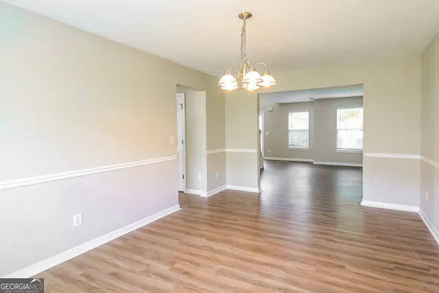 a view of a livingroom with a chandelier wooden floor and chandelier