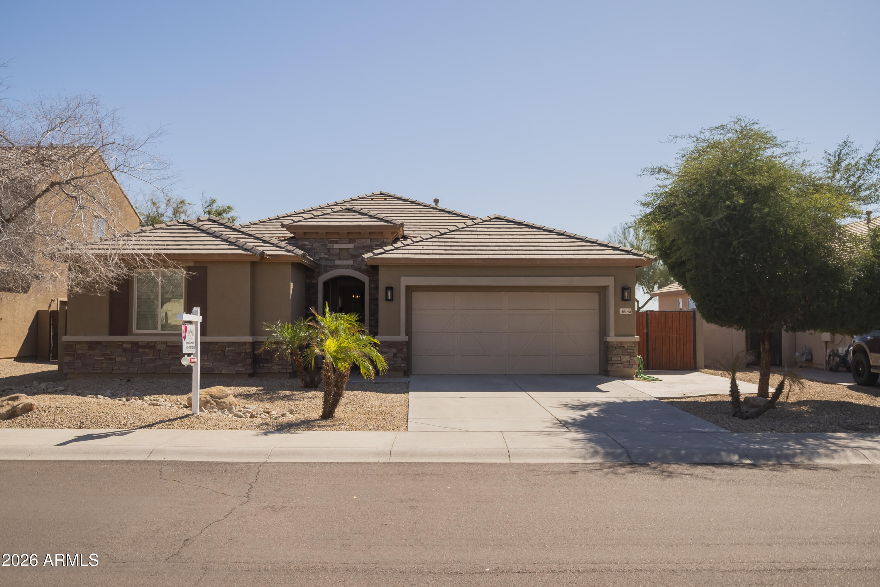 16045 West Almeria Road Goodyear, AZ 85395 - Photo 1 of 31 a front view of a house with a garden and mountain view