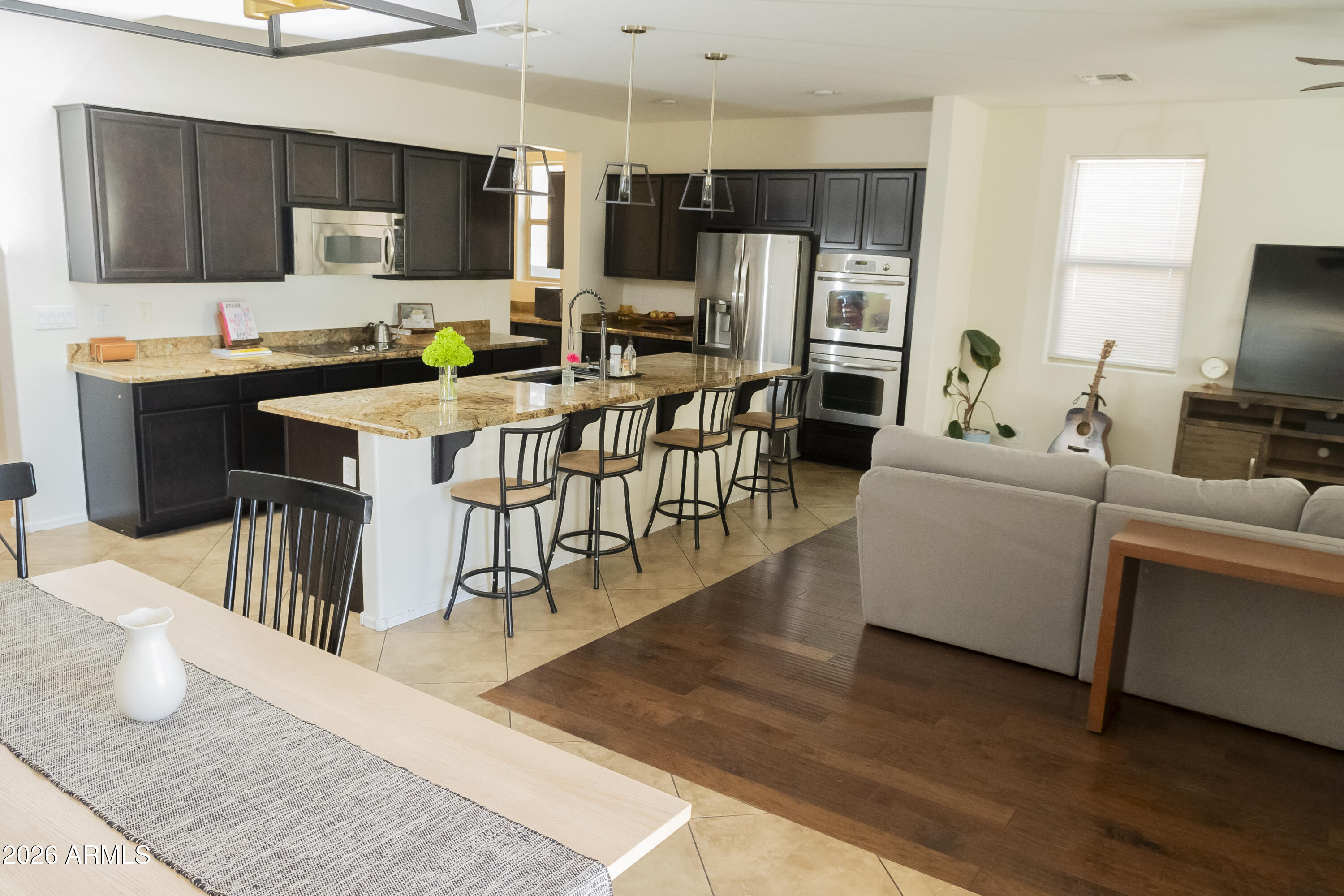 16045 West Almeria Road Goodyear, AZ 85395 - Photo 11 of 31 a living room with stainless steel appliances furniture and a kitchen view