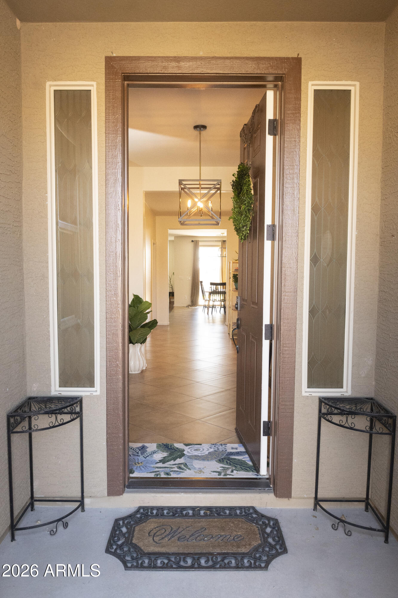 16045 West Almeria Road Goodyear, AZ 85395 - Photo 4 of 31 a view of a hallway with a living room and dining room