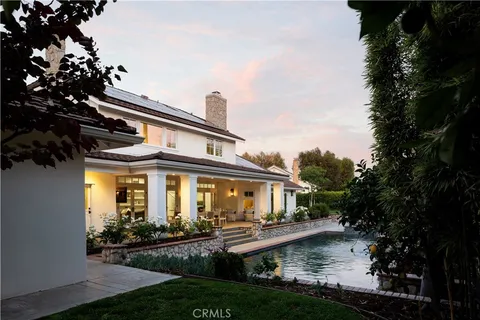 a front view of a house with swimming pool and porch with furniture