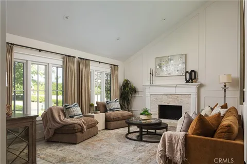 a living room with furniture a large window and a fireplace