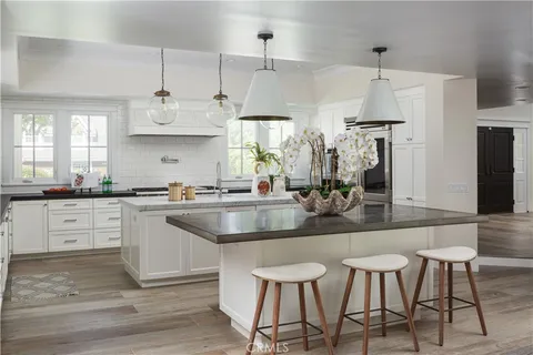 a kitchen with stainless steel appliances kitchen island granite countertop a sink and refrigerator