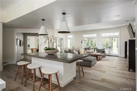 a living room with furniture a large window and wooden floor