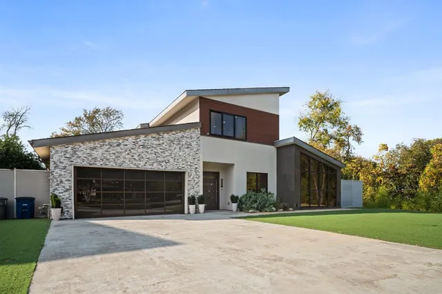 a front view of a house with a garden and trees