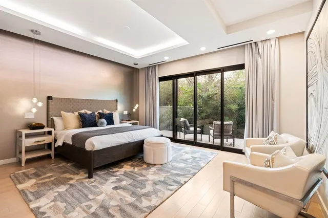 a spacious bedroom with a bed and glass walk in closet