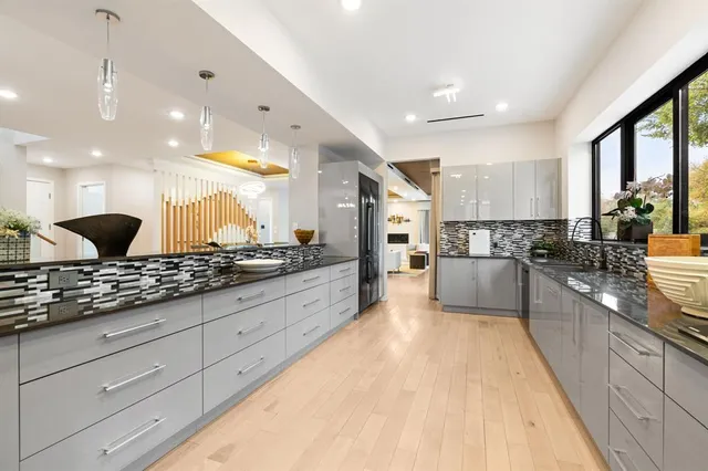 a large white kitchen with a large window