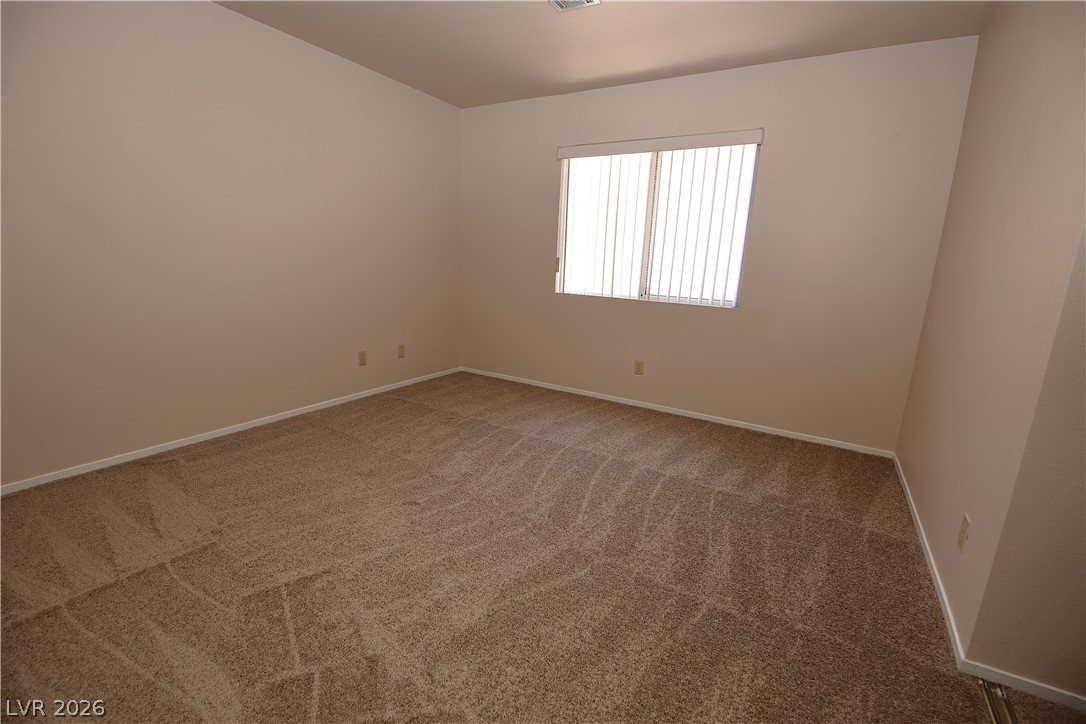 8220 Maplestar Road Las Vegas, NV 89128 - Photo 19 of 29 A spacious room offers plush carpeting and ample natural illumination through a wide window.