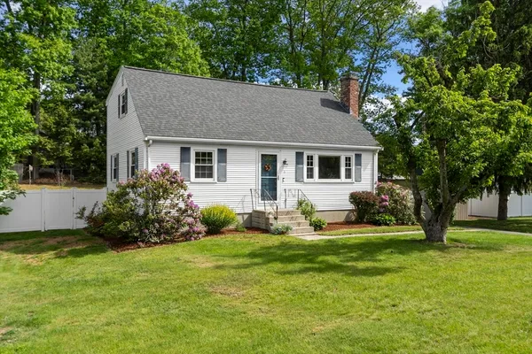 a view of a house with a yard and trees