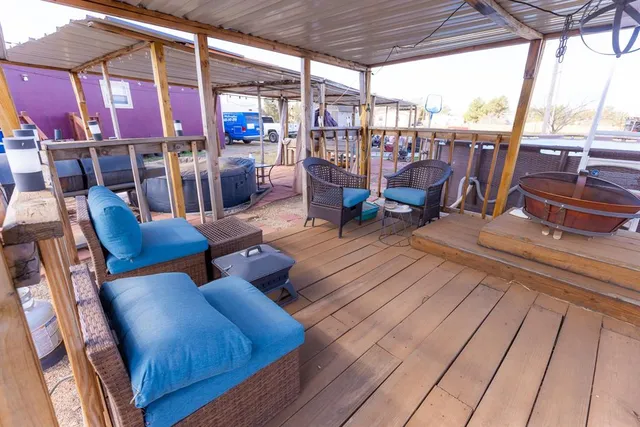 a view of a patio with couches chairs and wooden floor