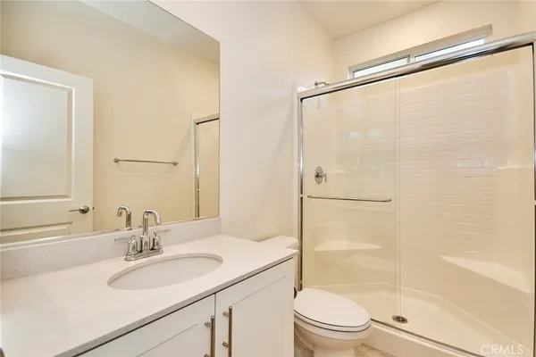 a bathroom with a sink a mirror toilet and shower