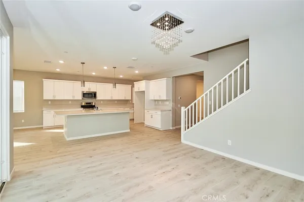 a view of kitchen with kitchen island white cabinets and stainless steel appliances
