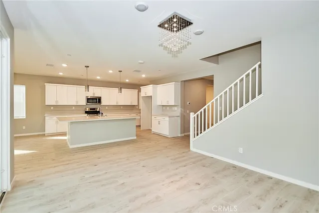 a view of kitchen with kitchen island white cabinets and stainless steel appliances