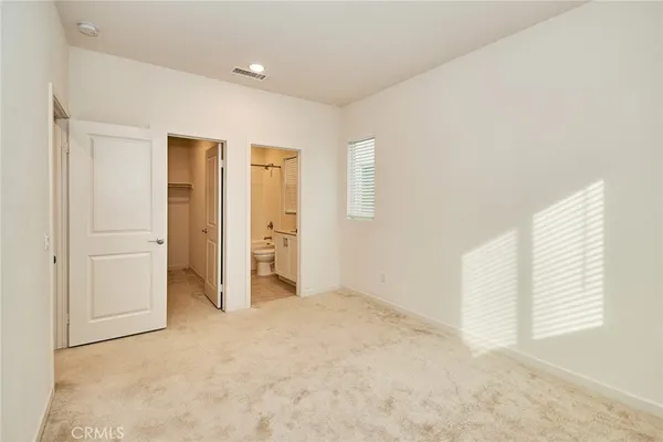 an empty room with windows and closet