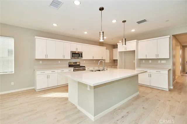 a large kitchen with kitchen island a sink a stove a center island a center island and cabinets