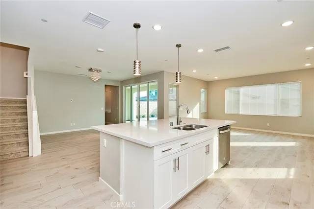 a kitchen with a sink stove and wooden floor