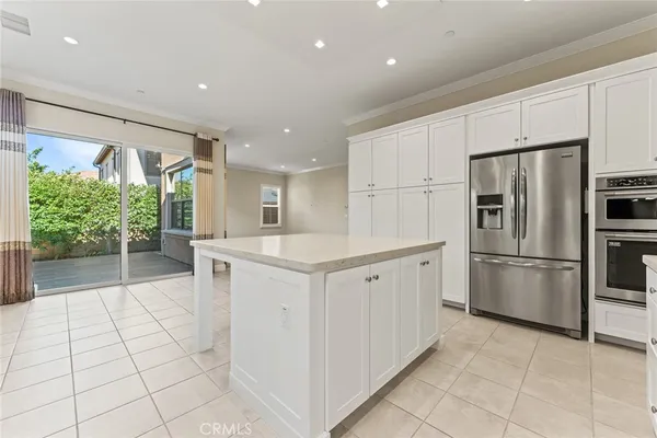 a kitchen with white cabinets a refrigerator and a sink