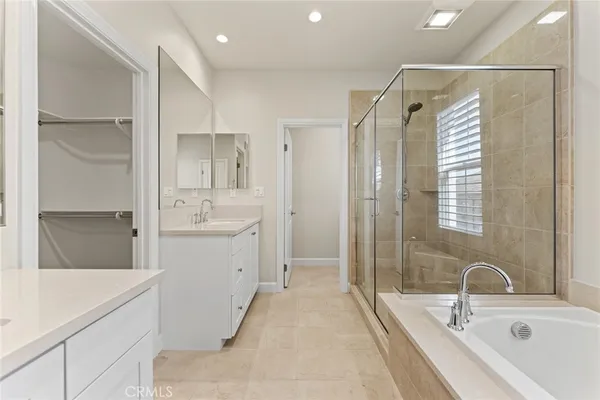 a bathroom with a tub sink shower and mirror
