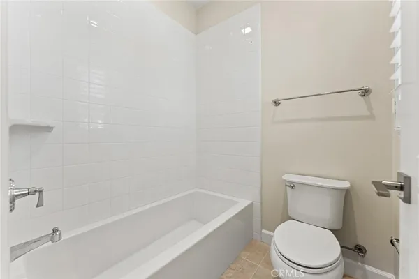 a white toilet and tub next to a bathroom sink