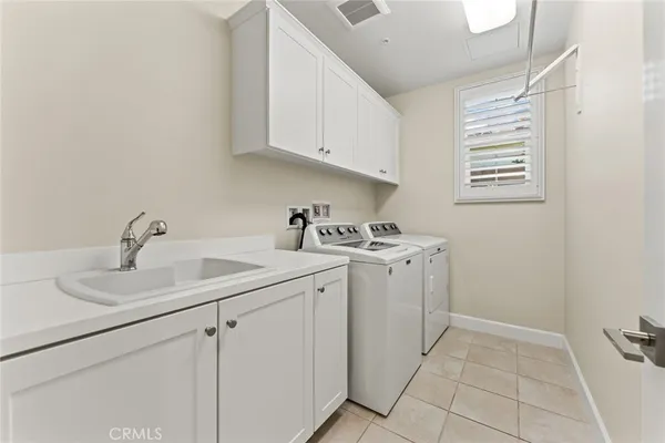 a utility room with sink dryer and washer