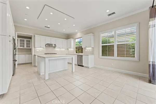 a kitchen with white cabinets and window