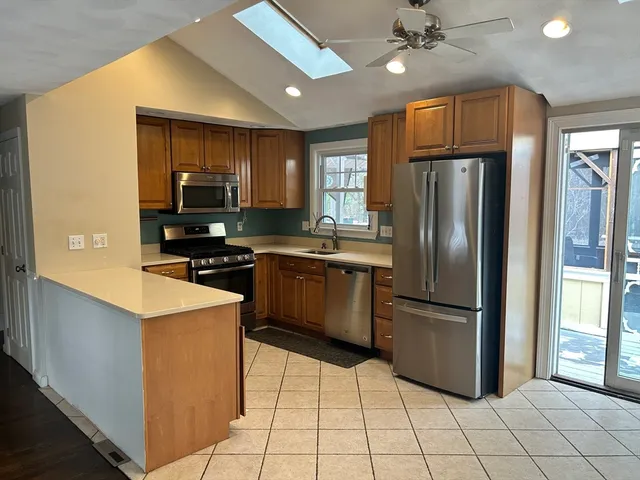 a kitchen with stainless steel appliances granite countertop a refrigerator a stove a sink dishwasher and a refrigerator with wooden floor