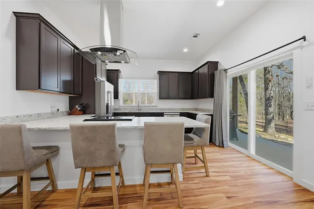 a kitchen with granite countertop a table chairs stove and microwave