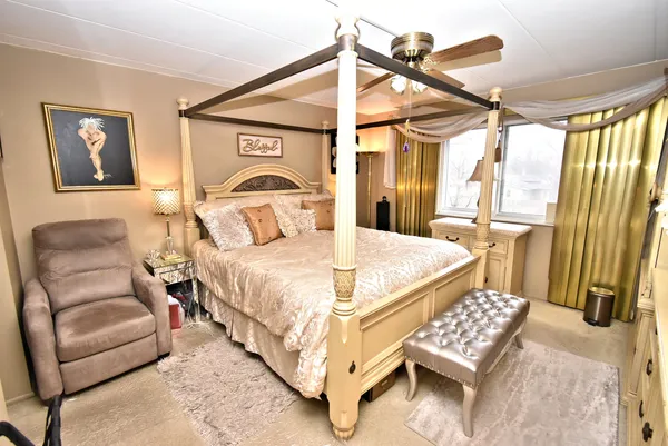 a bedroom with a bed couch and a window