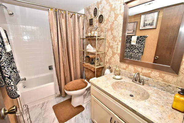 a bathroom with a sink toilet and shower