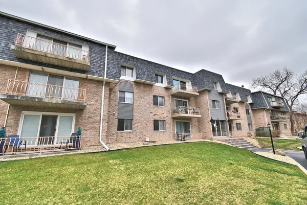 front view of a brick building with a yard