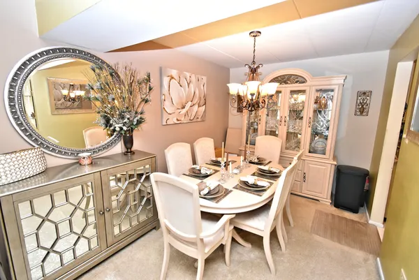 a dining room with furniture a chandelier and wooden floor