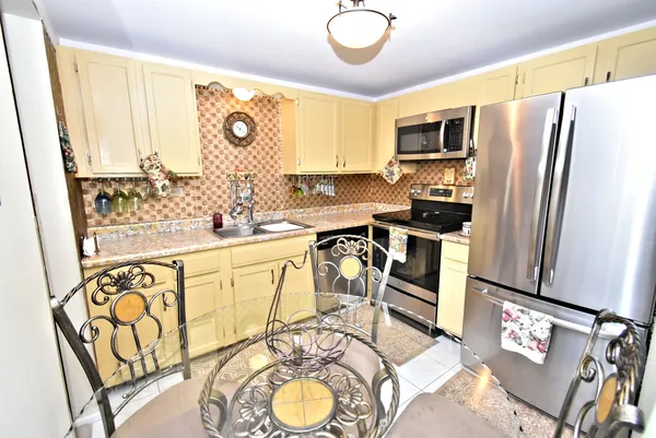 a kitchen with stainless steel appliances a refrigerator sink and stove