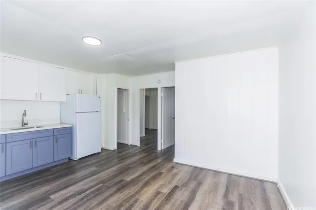 a view of a kitchen with white cabinets and wooden floor