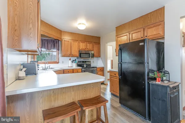 a kitchen with stainless steel appliances granite countertop a refrigerator a stove and a sink