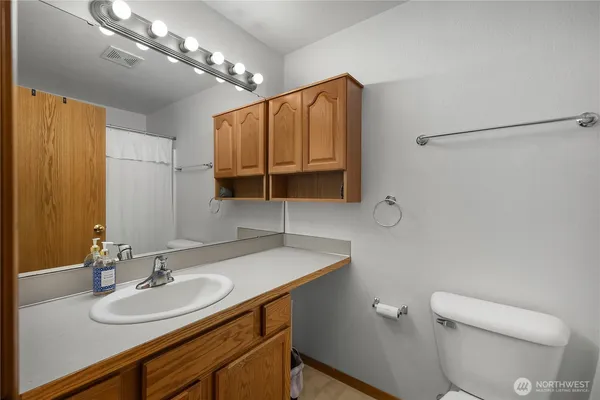 a bathroom with a sink a toilet and a mirror