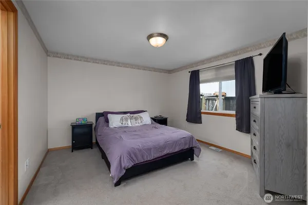 a bedroom with a bed and a flat screen tv