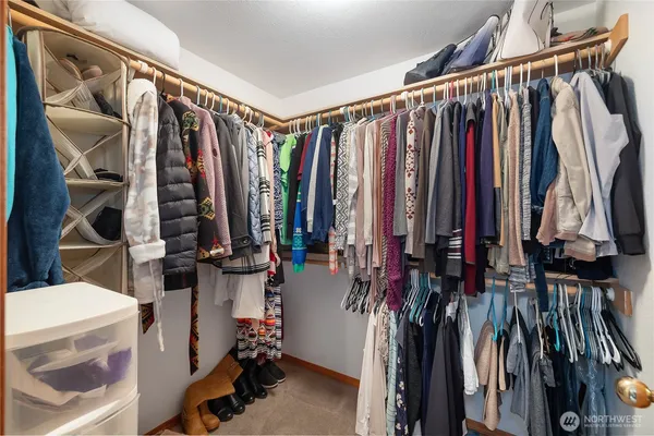 a view of walk in closet with clothes and shoes